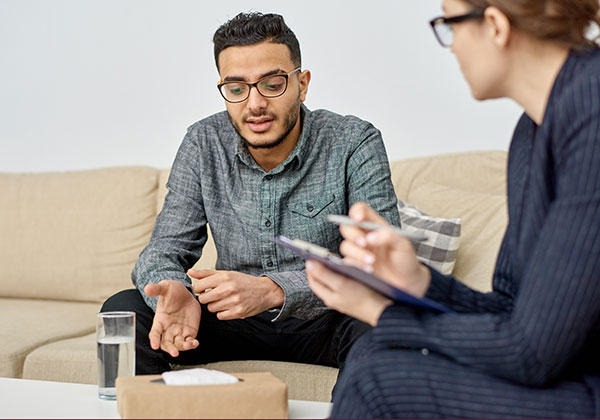 Young Middle-Eastern man discussing something with a professional.